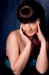 Beautiful brunette in color dress posing in studio.