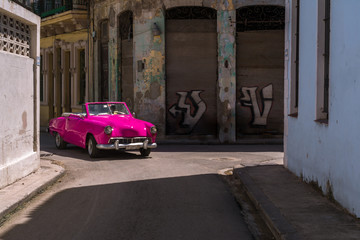 Un carro antiguo muy bonito sale de una calle de la Habana Vieja Cuba.