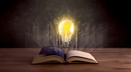 Shiny alphabet letters and yellow lightbulb hovering over open book 