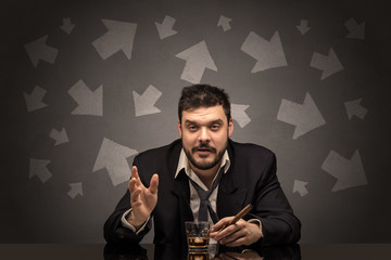 Drunk disappointed man sitting at table with arrows around

