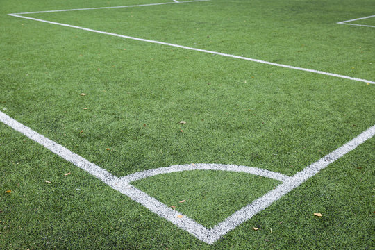 Corner kick line of football and soccer field, artificial green grass texture on soccer stadium. Sport concept. Closeup