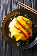 Japanese cuisine: omurice with rice, chicken and vegetables close-up. Vertical top view