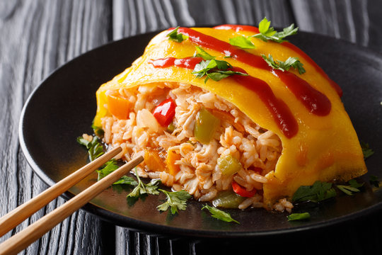 Japanese cuisine: omurice with rice, chicken and vegetables close-up on the table. horizontal