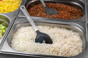White boiled rice in metal container. Canteen, catering.