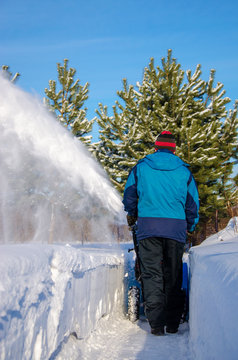 Cleaning snow in the yard of a snowplow
