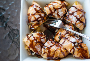 Chocolate and condensed sweet milk crunchy toast cut into pieces on white square bowl