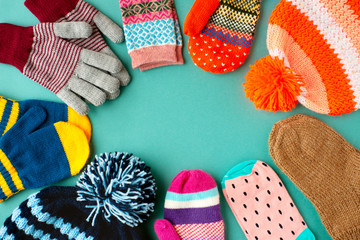 Caps, mittens, gloves and socks are stacked in a circle. View from above. Warm clothes in the form...