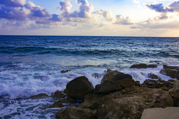 Obraz premium Landscape of the sundown in sea water amongst rocky beach