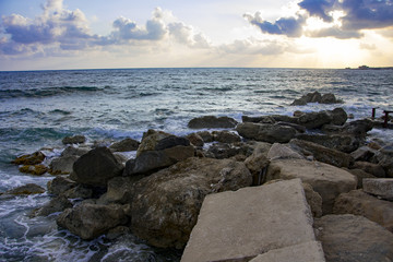 Fototapeta na wymiar Landscape of the sundown in sea water amongst rocky beach