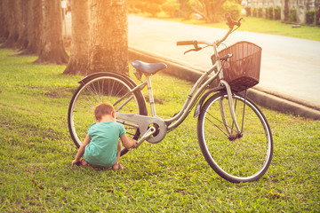 Boy with a bikecycle in the grass.