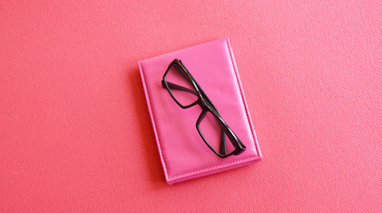 black-rimmed glasses on a pink background
