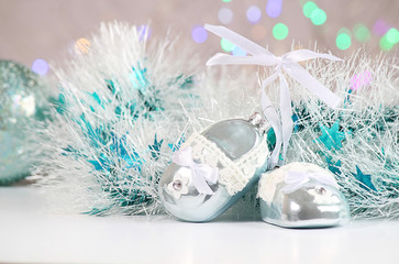 New Year or Christmas decorations on an abstract background, bokeh effect. White tinsel with turquoise stars. Can be used as wallpaper or greeting card. Selective focus, copy space.