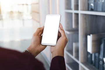 Mockup image of man's hands holding white mobile phone with blank screen technology and lifestyle concept.