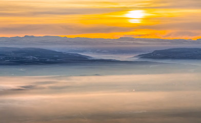 Fototapeta premium Mountains in the fog, haze. The Main Caucasian Range. Multicolored background. Mountains at sunset. Winter fog.