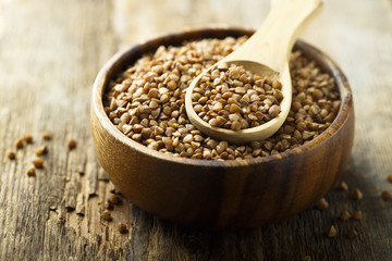 Raw buckwheat in the wooden bowl