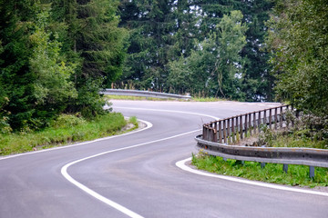 asphalted road leading up to the mountains in forest
