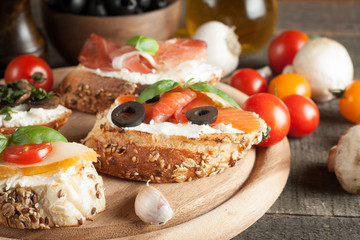 Italian tomato and cheese bruschetta. Tapas, antipasti with chopped vegetables, herbs and oil on grilled ciabatta and baguette bread.