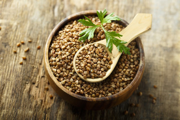 Raw buckwheat in the wooden bowl