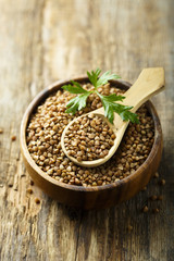 Raw buckwheat in the wooden bowl