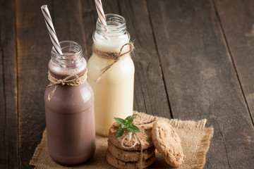 Photo of fresh Made Chocolate Banana Smoothie on a wooden table with cookies, banana and coconut. Milkshake. Protein diet. Healthy food concept. Drink, coffee beans, chocolate.