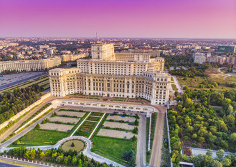 Parliament building or People's House in Bucharest city. Aerial view at sunset with abstract pink sky