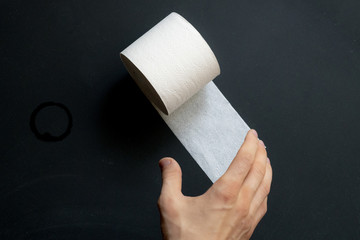 close up hand grab take the toilet paper roll on dark black surface a