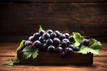 Fototapeta premium Purple vine grapes in wooden crate