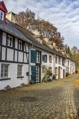 Colorful cobblestone street view of Kronenburg, North Rhine-Westphalia, Germany, adjoining buildings against a November cloudy sky