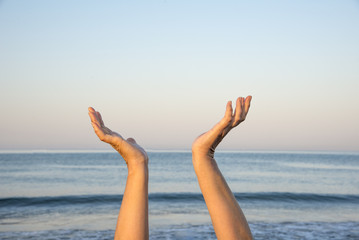 Hands up in the air by the sea. The hope and spiritual concept