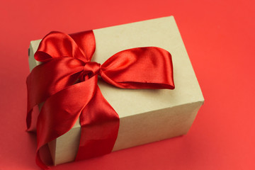 gift box with red satin ribbon on a red background