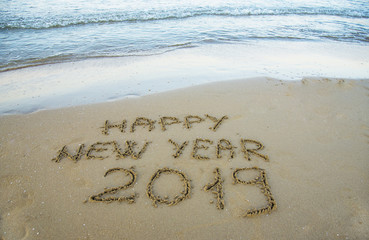 Happy new year written on the sand