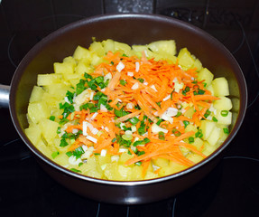  Stewed vegetables, zucchini, carrots, onions. Frying pan with stewed vegetables on the stove. The preparation of the meal