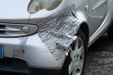 Damaged car front, repaired with duct tape