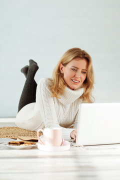 Cheerful freelance worker usig her laptop
