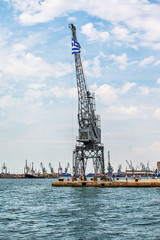 Fototapeta premium Thessaloniki, Greece - August 16, 2018: Coast of historical cityview with traditional winches at harbour of Thessaloniki, Greece