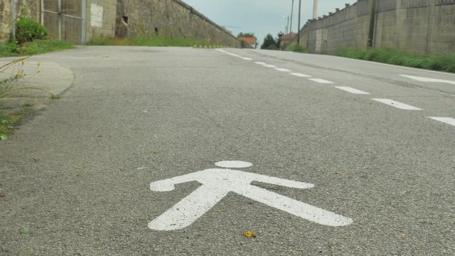 white color walking man road sign on the floor