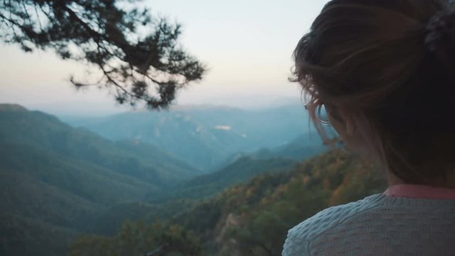 The girl looks at the mountains