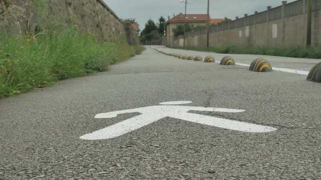 white color walking man road sign on the floor