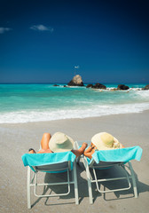 Couple on sunbeds relaxing at the beach in Lefkada