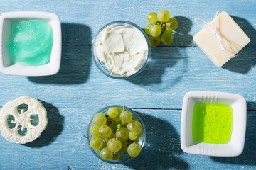 beauty product samples from grape seed ingredient, blue wooden table background