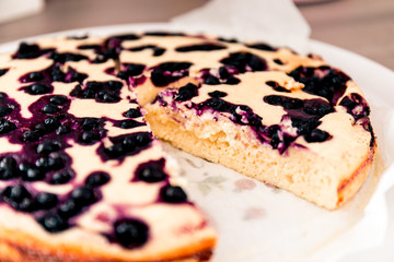 Cut homemade casserole pie with cottage cheese with blueberries.