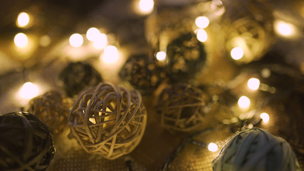 Close-up christmas garland and handmade balls on a playd with golden lights. Christmas concept. Home decor