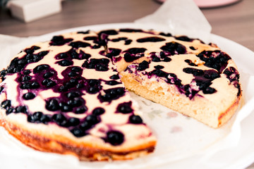 Cut homemade casserole pie with cottage cheese with blueberries.