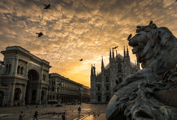 milan duomo cathedral with lion sculpture and galleria vittorio Emanuele dramatic sunset 