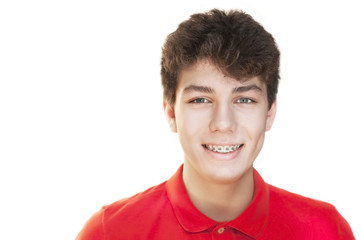 Young boy in a red shirt on a white background smiles fun. He is glad that he will have beautiful...