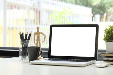 Fototapeta premium Workspace laptop computer, coffee, pencil and plant decoration with big window and nature on background.