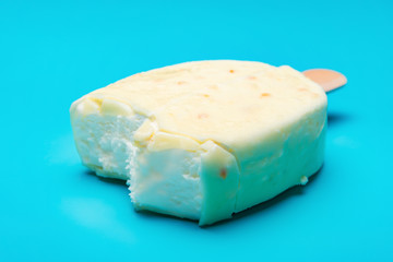 white popsicle with some bites on blue background