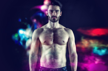 Fototapeta na wymiar Handsome young muscular man shirtless, on black background in studio shot