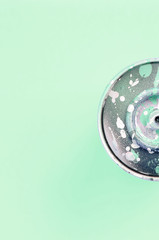 Single used spray can for graffiti drawing lies on a pastel colored backgroung. Street art painting...