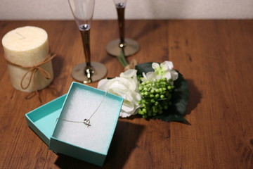 ネックレスのプレゼントとワイングラスと薔薇とキャンドル	